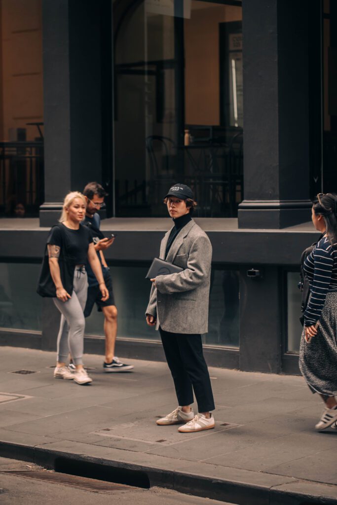 NOTA man in suit reading notebook, standing outside on melbourne street