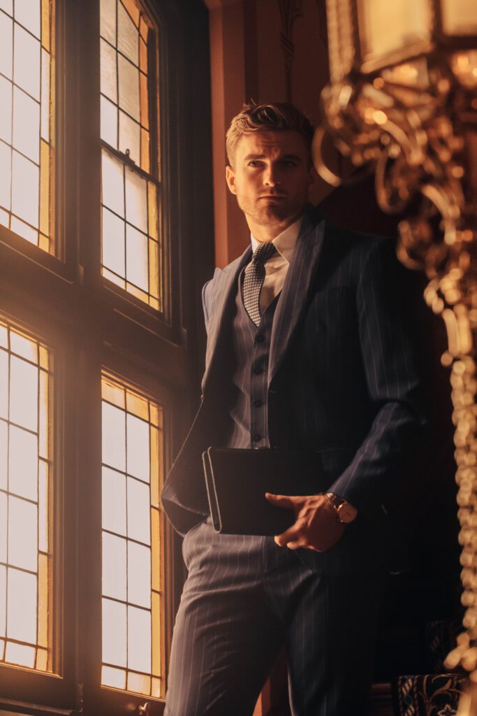 NOTA man in suit reading notebook, professional studio photo and model, in public in melbourne building, sitting next to window, old style building, old anz building